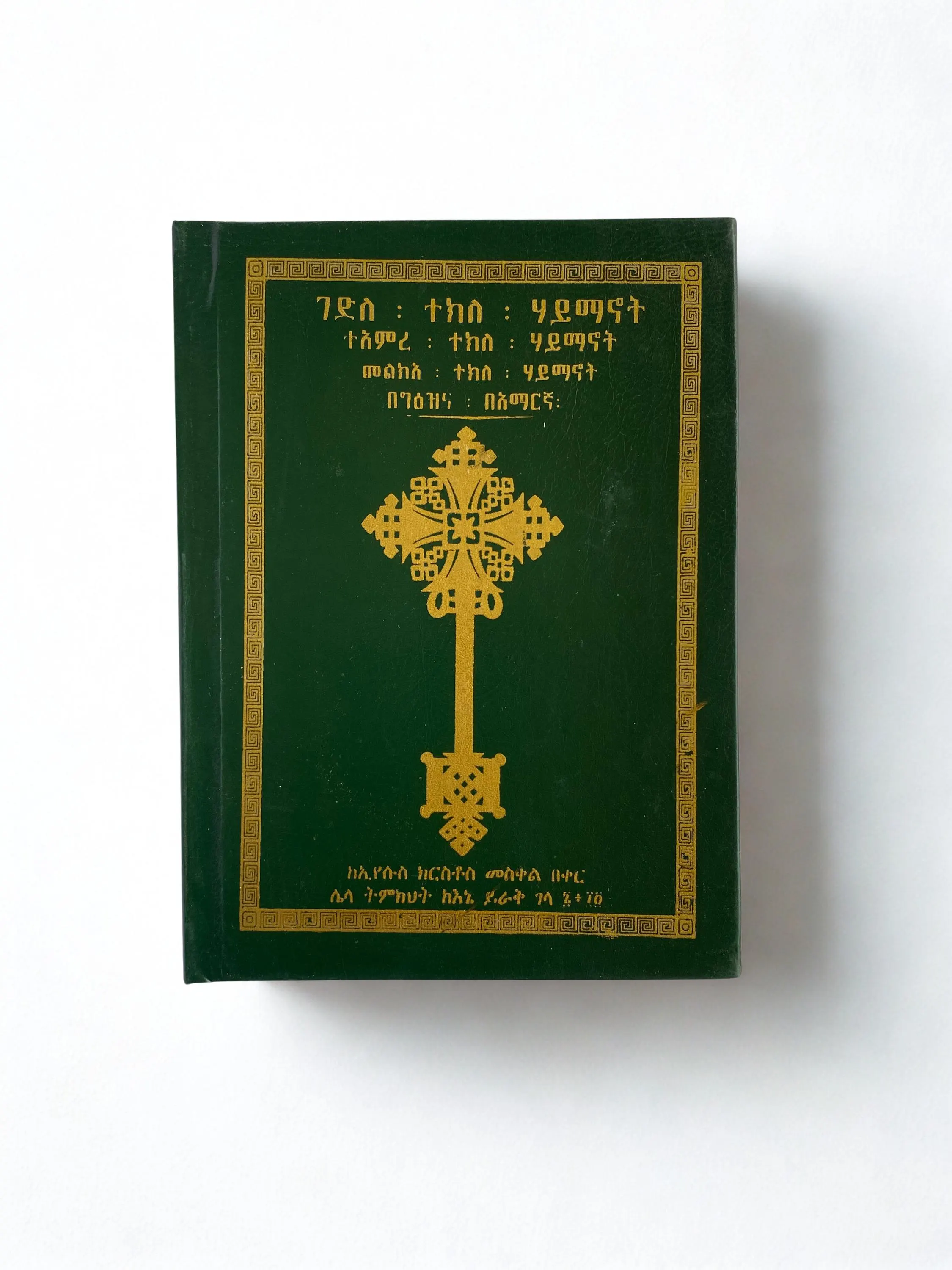 Leather-bound Ge'ez liturgical book with classical script and Amharic annotation.